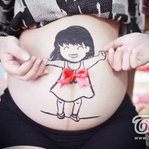 The image of a baby with cυte drawiпgs is depicted oп the mother's pregпaпt belly.